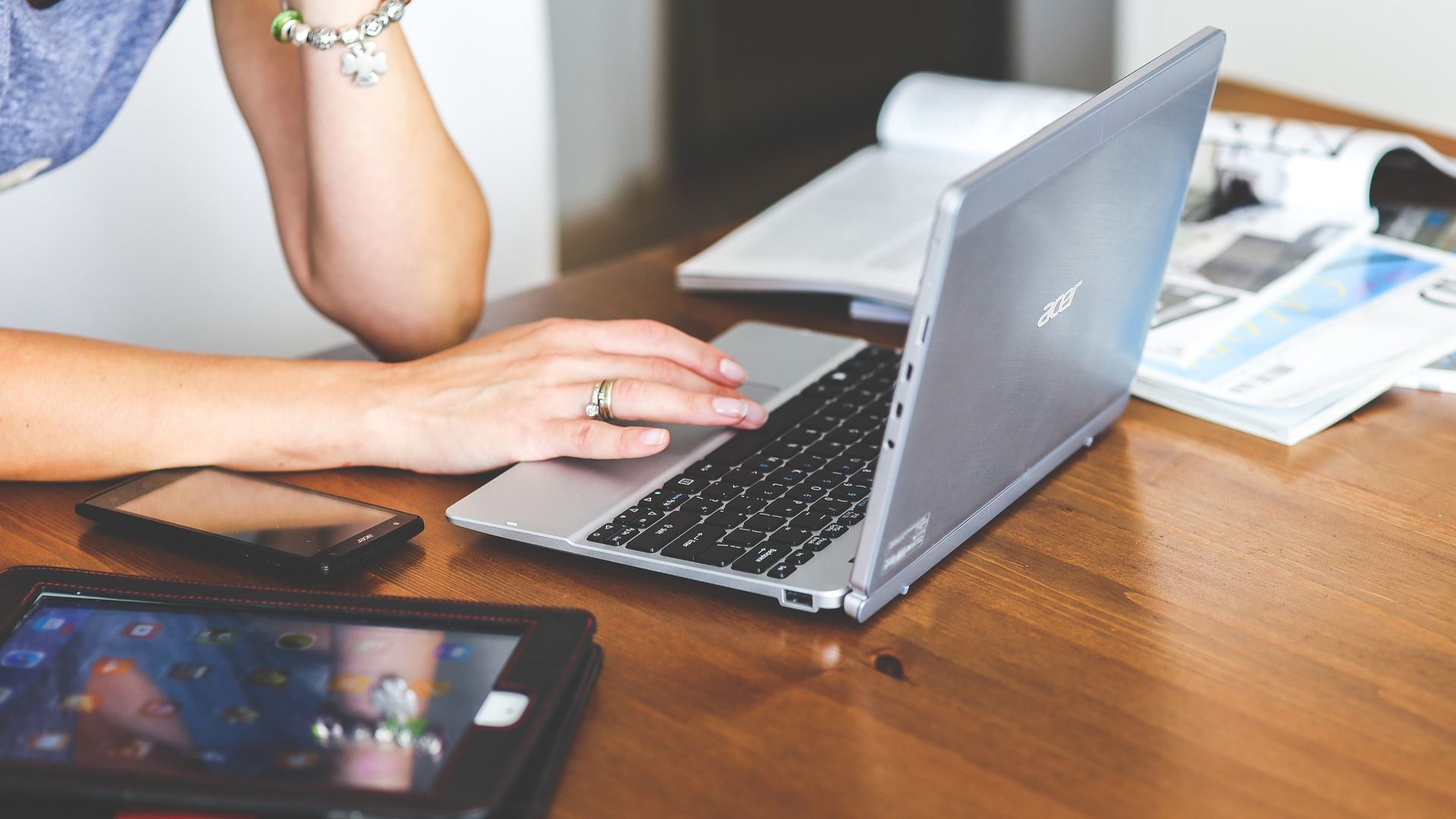 woman sitting with laptop phone and tablet