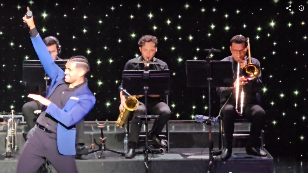 two horn players and singer at a live performance