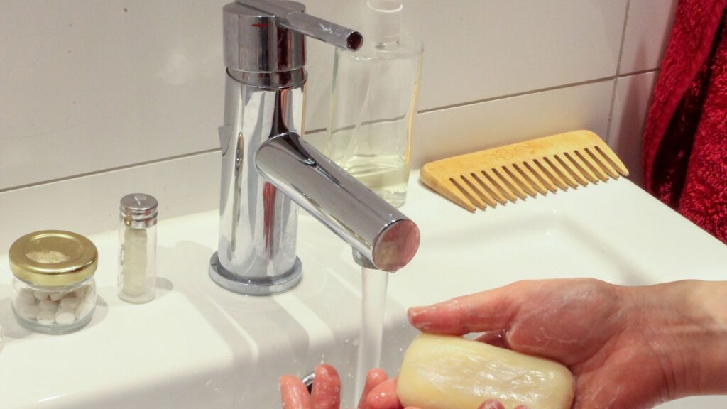 person washing hands with bar of soap