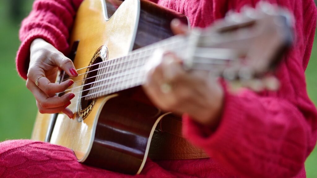 woman in red playing guitar